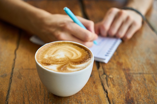 Decorative image of coffee and person writing in the background